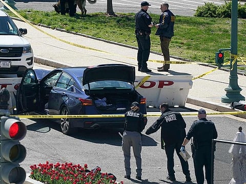 U.S. Capitol Police officers stand near a car that crashed into a barrier on Capitol Hill in Washington, Friday, April 2, 2021