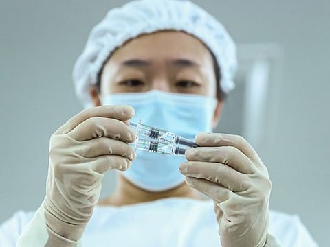 A Chinese staff member checks the packaging quality of COVID-19 inactivated vaccine products at a packaging plant in Beijing.
