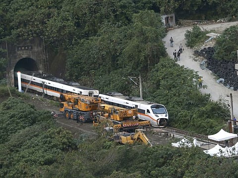 Rescue workers remove part of the derailed train near Taroko Gorge in Hualien, Taiwan on Saturday, April 3, 2021. The train partially derailed in eastern Taiwan on Friday after colliding with an unmanned vehicle that had rolled down a hill, killing and injuring dozens.