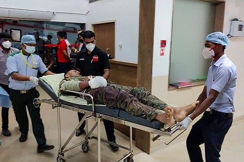 Medical workers bring an injured soldier on a stretcher for treatment in a hospital following a gun battle with Maoist rebels.