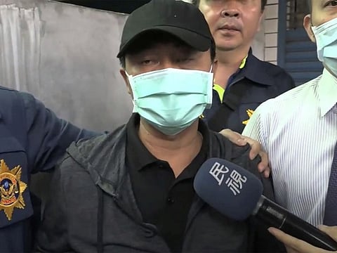 In this image taken from video, Lee Yi-hsiang, the driver of the truck that caused the train accident on Saturday, offers a public apology as he is led by police Sunday, April 4, 2021, in Hualien, Taiwan. Lee's truck slid into the path of an oncoming train, causing Taiwan's worst railway accident in decades that which killed dozens of people, and injuring hundreds more.