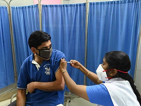 A medical worker inoculates a man with the Covaxin COVID-19 coronavirus vaccine, at a health centre in New Delhi on April 6, 2021.