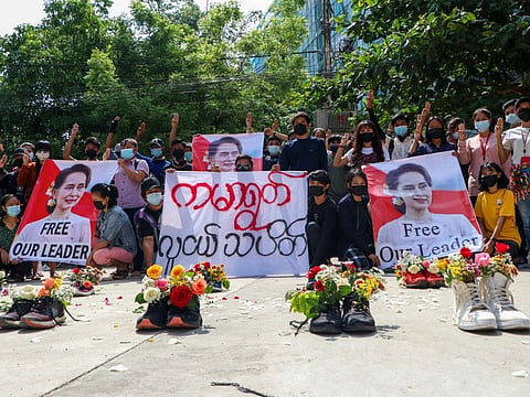 Anti-coup protesters gather at Kamayut township in Yangon, Myanmar Thursday, April 8, 2021, with shoes willed with flowers. They walked through the markets and streets of Kamayut township with slogans to show their disaffection for military coup. A sign, center, reads " Kamayut Youth Strike."