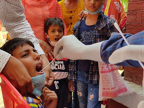 A health worker takes swab sample of children to test for COVID-19 in Prayagraj, India