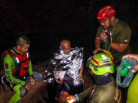 This handout from the Prasatbunyasathan Foundation taken on April 7, 2021 and received on April 8, 2021 shows Buddhist monk Manas Kemgoh (2nd L), who had been trapped in a flooded cave while meditating, surrounded by rescue workers in Phra Sai Ngam cave in Thailand's Phitsanulok province.