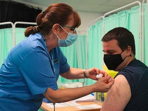 A healthcare professional administers an injection of the Moderna COVID-19 vaccine at a vaccination centre at Ffwrnes Theatre in Llanelli, South Wales, on April 9, 2021.