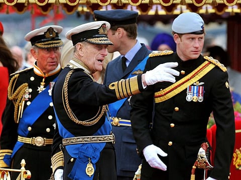 In this file photo taken on June 03, 2012 Members of the Royal family (from left to right) Prince Charles, Prince of Wales, Prince Philip, Duke of Edinburgh, Prince William and Prince Harry talk onboard the Spirit of Chartwell during the Thames Diamond Jubilee Pageant on the River Thames in London. “Harry will come home, and a meeting between the brothers and perhaps, with luck, a reconciliation over their dead grandfather could be a possibility,” said Penny Junor, a royal historian.