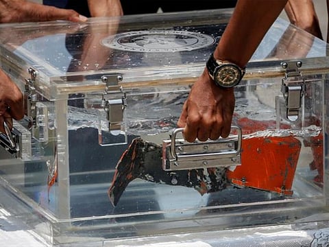 National Transportation Safety Committee (KNKT) officials place the Cockpit Voice Recorder (CVR) of Sriwijaya Air flight SJ 182 on a table at Tanjung Priok Port in Jakarta, Indonesia.
