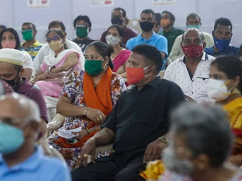People wait for a mandatory observation after being administered the AstraZeneca vaccine for COVID-19 at a vaccination centre in Mumbai, India, Sunday, April. 11, 2021.