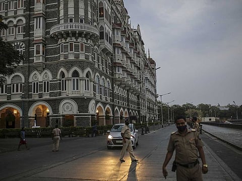 Police officials stand near the Taj Mahal Hotel during a weekend lockdown in Mumbai, India, on April 10, 2021.