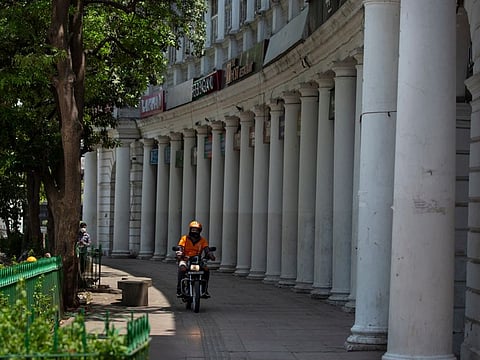 A man rides a bike in a deserted market area during a weekend lockdown in New Delhi, India, Saturday, April 17, 2021. Over 200,000 new infections were detected in the past 24 hours, and major cities, like Mumbai and New Delhi, are under virus restrictions