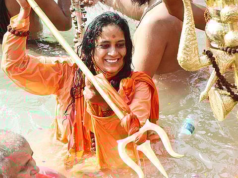 A Sadhvi of Niranjani Akhada takes a holy dip at Har ki Pauri during Kumbh, in Haridwar on Wednesday.