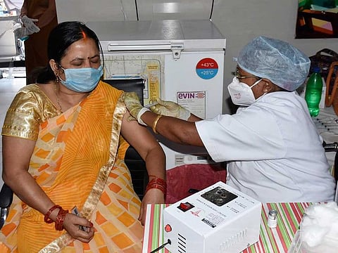 A medic gives the first dose of COVID-19 vaccine to to a woman at a government dispensary in Patna on Monday, April 19, 2021.