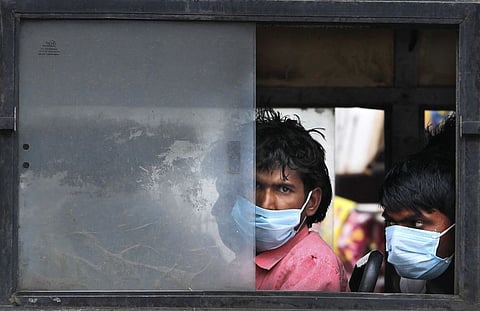 Migrant laborers sit in a bus to travel to their villages following a lockdown put into place to control the rising cases of coronavirus infections, in New Delhi, India, Tuesday, April 20, 2021