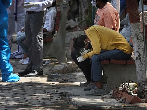 Heartbreak: A relative of a person who died of COVID-19 reacts during cremation, in New Delhi, India