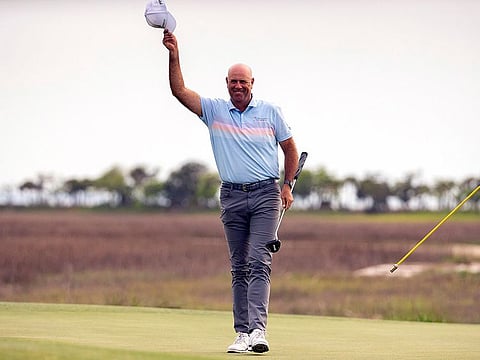 Stewart Cink tips his cap to the crowd after sinking the winning putt on the 18th green during the final round of the RBC Heritage golf tournament.