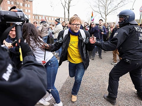 A demonstrator runs past a police officer during a protest against the government measures to curb the spread of the coronavirus disease (COVID-19), on the day of discussion in the lower house of parliament Bundestag regarding additions for the Infection Protection Act, in Berlin, Germany April 21, 2021.