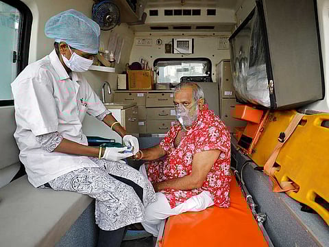 A paramedic uses an oximeter to check the oxygen level of a patient inside an ambulance while waiting to enter a COVID-19 hospital for treatment, amidst the spread of the coronavirus disease (COVID-19) in Ahmedabad, India, April 22, 2021.