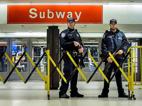 Police stand guard inside the Port Authority Bus Terminal following an explosion near Times Square, in New York.