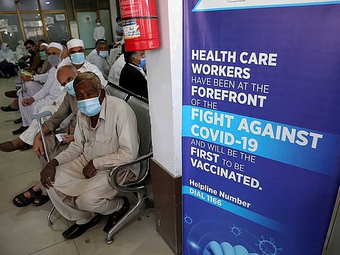 People await their turn to receive the second jab of the Sinopharm COVID-19 vaccine at a vaccination centre, in Peshawar, Pakistan, Wednesday, April 21, 2021.