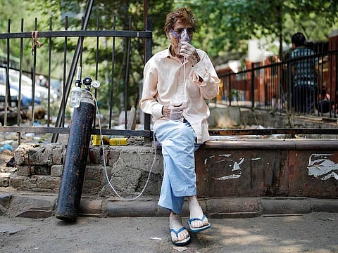 A patient, wearing an oxygen mask, sits outside Lok Nayak Jai Prakash Narayan Hospital (LNJP), one of India's largest facilities for coronavirus disease (COVID-19) patients only, in New Delhi, India