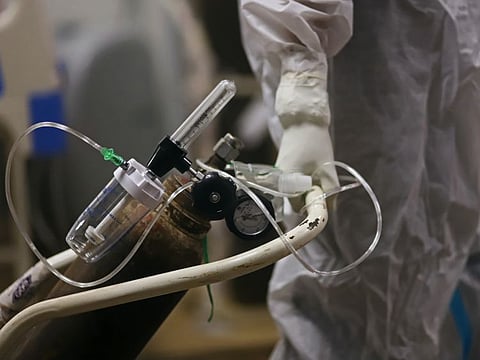 A health worker wheels an oxygen canister in a COVID-19 hospital set up inside a stadium in New Delhi, India, on Friday, April 23, 2021. Bodies piling up at crematoriums and burial grounds across India are sparking concerns that the death toll from a ferocious new COVID-19 wave may be much higher than official records, underplaying the scale of a resurgence that is overwhelming the country’s medical system.