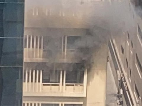 Smoke arises from the window of the apartment in Sharjah.