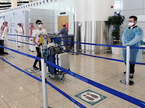 A traveller wheels his bags at Riyadh International Airport.