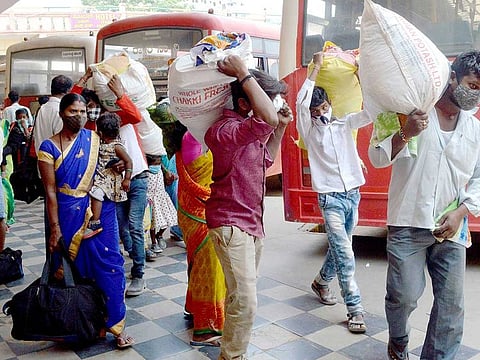 Passengers arrive to board a bus at the bus stand after the government announced 14 days of close down, in Bengaluru on Tuesday, April 27, 2021.