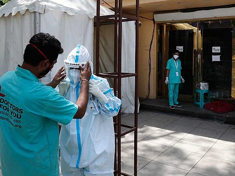 File photo: A health worker adjusts the face shield of another as she prepares to go inside a quarantine center for COVID-19 patients in New Delhi, India.