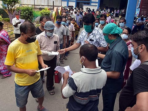 People show registration slips to get COVID-19 vaccine outside a government hospital amid the rise in coronavirus cases, in Kolkata on Friday, April 30, 2021.