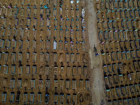 Aerial view of a gravedigger walking among COVID-19 victims' graves at the Nossa Senhora Aparecida cemetery in Manaus, Amazonas state, Brazil, on April 29, 2021. Brazil surpassed Thursday 400,000 deaths due to COVID-19, and is second in number only to the US.