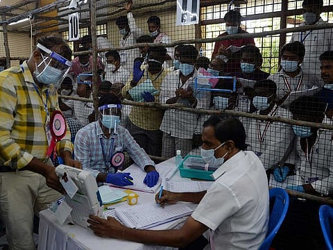 Electoral officials hold an Electronic Voting Machine (EVM) to display the number of votes at a counting center for the Tamil Nadu's state legislative assembly elections in Chennai on May 2, 2021.