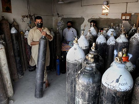 A vendor arranges oxygen cylinders which will be supplied to customers for COVID-19 patients, in Peshawar, Pakistan, Friday, April 30, 2021.
