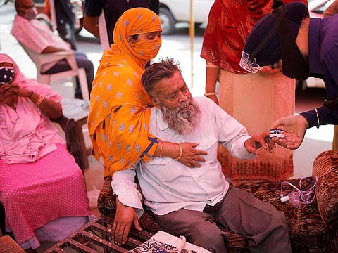 A volunteer uses a pulse oximeter to check the oxygen saturation of a man's blood before providing him oxygen support for free at a Gurudwara (Sikh temple), amidst the spread of coronavirus disease (COVID-19), in Ghaziabad, India, May 3, 2021.