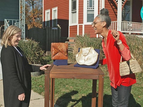This image released by WGBH-TV shows Katy Kane, left, as she appraises celebrity chef Carla Hall’s vintage purse collection in an episode of "Antiques Roadshow Celebrity Edition".