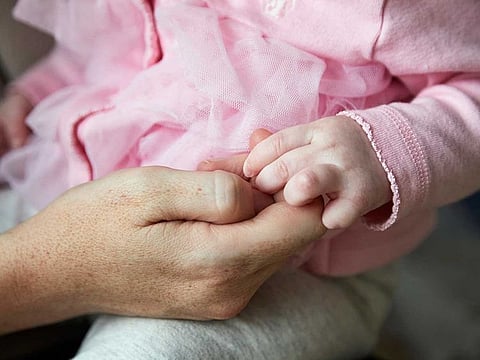 A mother holds the hand of her infant daughter in East Amherst, New York, on Dec. 5, 2020. The birthrate in the United States has fallen by about 15 per cent since its recent peak in 2007.