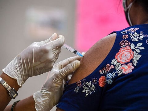 A health worker inoculates a woman with a dose of Covaxin at a vaccination centre in New Delhi on May 5, 2021.