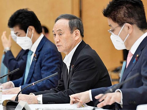 Japanese Prime Minister Yoshihide, centre, attends a meeting on the COVID-19 infections at the prime minister's office in Tokyo Friday, May 7,  2021.