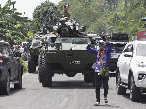 Armoured personnel carriers make their way along traffic as they augment security forces in Datu Paglas, Maguindanao province, southern Philippines on Saturday May 8, 2021. Dozens of Muslim rebels occupied a public market overnight in the southern Philippines before fleeing after a tense standoff with government forces, officials said Saturday.