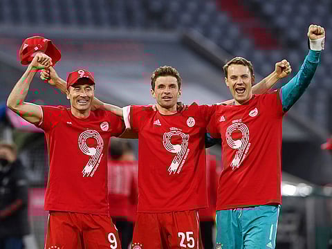 Bayern Munich's Thomas Muller, Manuel Neuer and Robert Lewandowski celebrate after the match after winning the Bundesliga.
