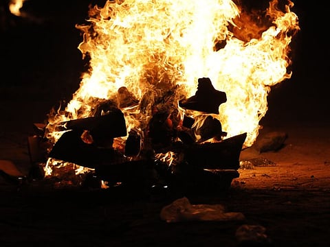 Relatives stand near the funeral pyre of their loved one who died due to COVID-19 at a cremation ground in Prayagraj, India, Saturday, May 8, 2021.