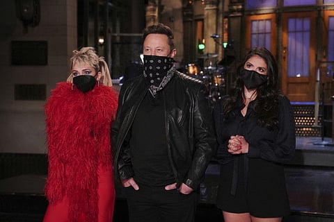 This image released by NBC shows musical guest Miley Cyrus, from left, host Elon Musk, and Cecily Strong during promos in Studio 8H on Thursday, May 6, 2021.