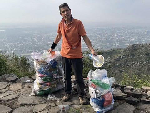 British High Commissioner Dr. Christian Turner with two bags full of trash in Margalla Hills National Park.