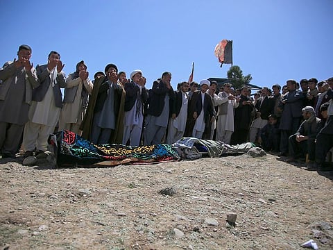 Afghans pray during the funeral of victims of deadly bombings near a school, at a cemetery west of Kabul, Afghanistan