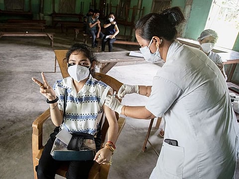 A woman getting vaccinated with a dose of COVAXIN against the coronavirus gestures to camera in Gauhati, Assam.