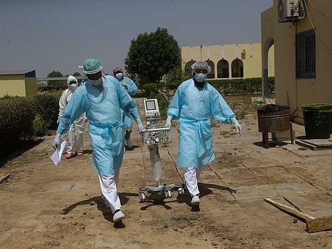 Doctors caring for COVID-19 patients ferry medical equipment, at the Farcha provincial hospital in N'Djamena, Chad, Friday April 30, 2021.