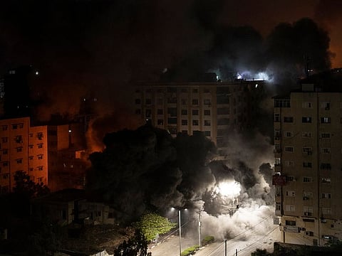 Smoke caused by Israeli airstrikes is seen on a residential building in Gaza City, early Wednesday, May 12, 2021.