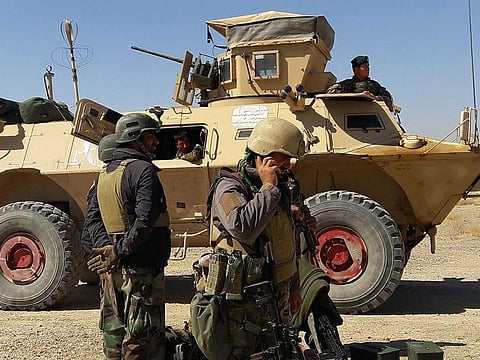 Afghan security forces stand near an armoured vehicle during ongoing fighting between Afghan security forces and Taliban fighters in the Busharan area on the outskirts of Lashkar Gah, the capital city of Helmand province May 5, 2021.
