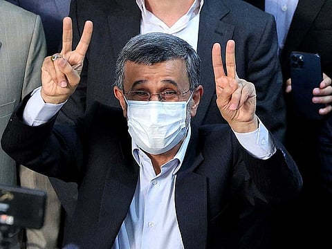 Iranian presidential candidate and former president Mahmoud Ahmadinejad, wearing a face mask due to the Covid-19 pandemic, flashes the victory sign as he registers his candidacy for the post of president of Iran, at the Interior Ministry in Tehran on May 12, 2021.